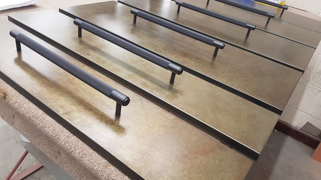 Aged zinc drawer fronts with powder-coated handles, fabricated for cabinetry